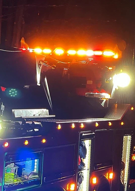 Tow truck running an amber LED light bar at night