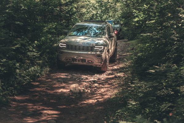 A four-wheel-drive vehicle on a backcountry off-road trail, illustrating Black Oak LED's off-road light bar range.