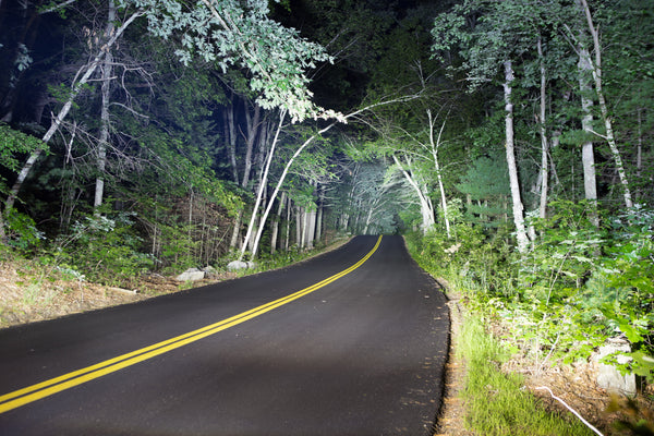 A Jeep Trailhawk on a rugged off-road trail with auxiliary LED lighting, a trail-ready vehicle geared up for backcountry travel.