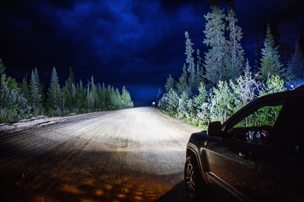 A Jeep Trailhawk equipped with Black Oak LED lights out on the trail, a rigged trail vehicle set up for unconventional adventures.