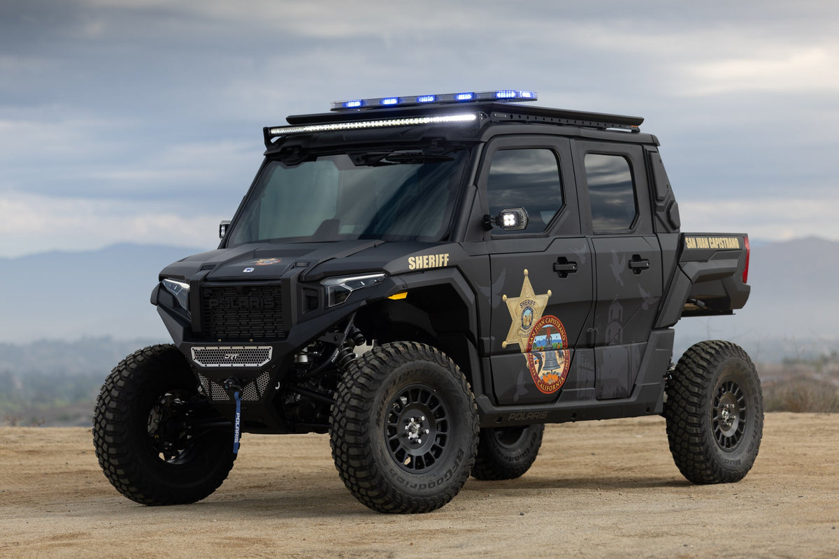 Patrol vehicle running a Black Oak LED Low Pro red and blue emergency light bar at night